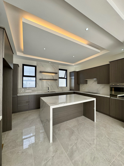 Modern kitchen with marble island and warm cove lighting