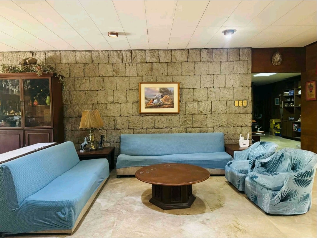 Family lounge with a dramatic stone feature wall and polished stone flooring