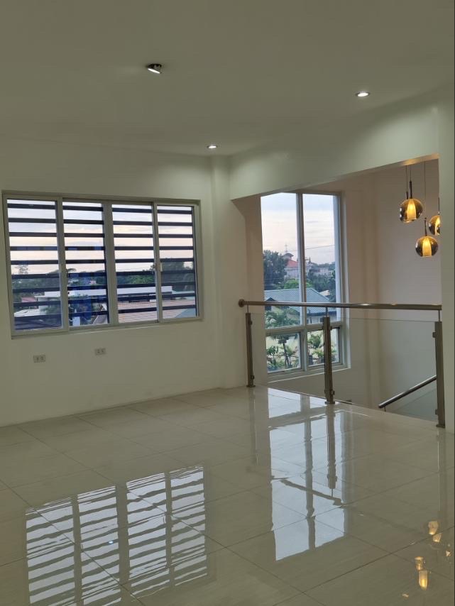 Bright upper living space with louvered windows and pendant lighting overlooking the village