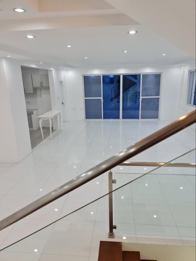 Open-plan living area with floor-to-ceiling glass doors and glossy tiled floors