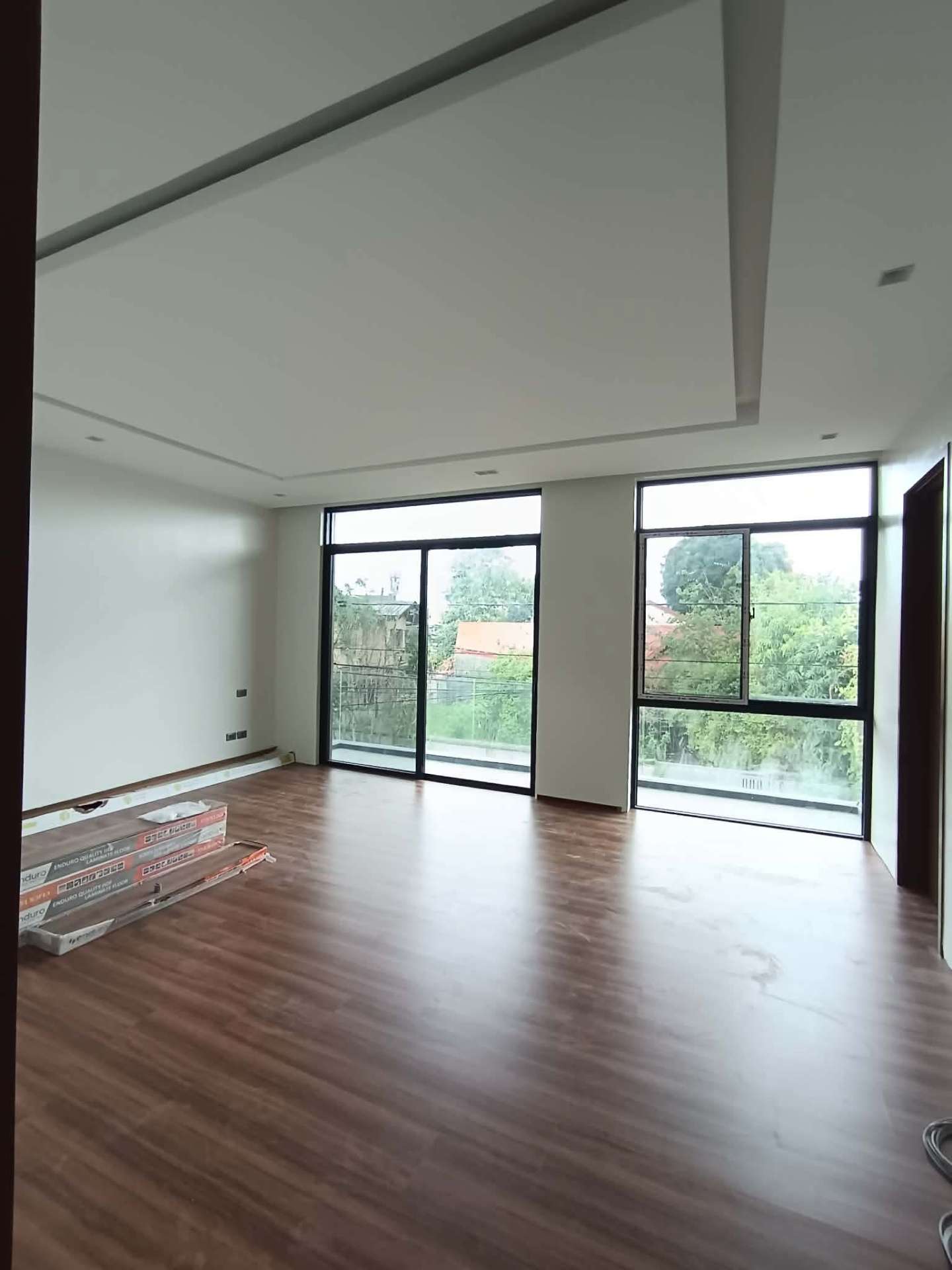 Bright family room with wood flooring and full-height windows to the balcony