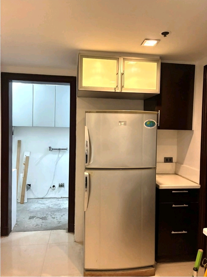 Kitchen area with refrigerator and adjoining laundry room