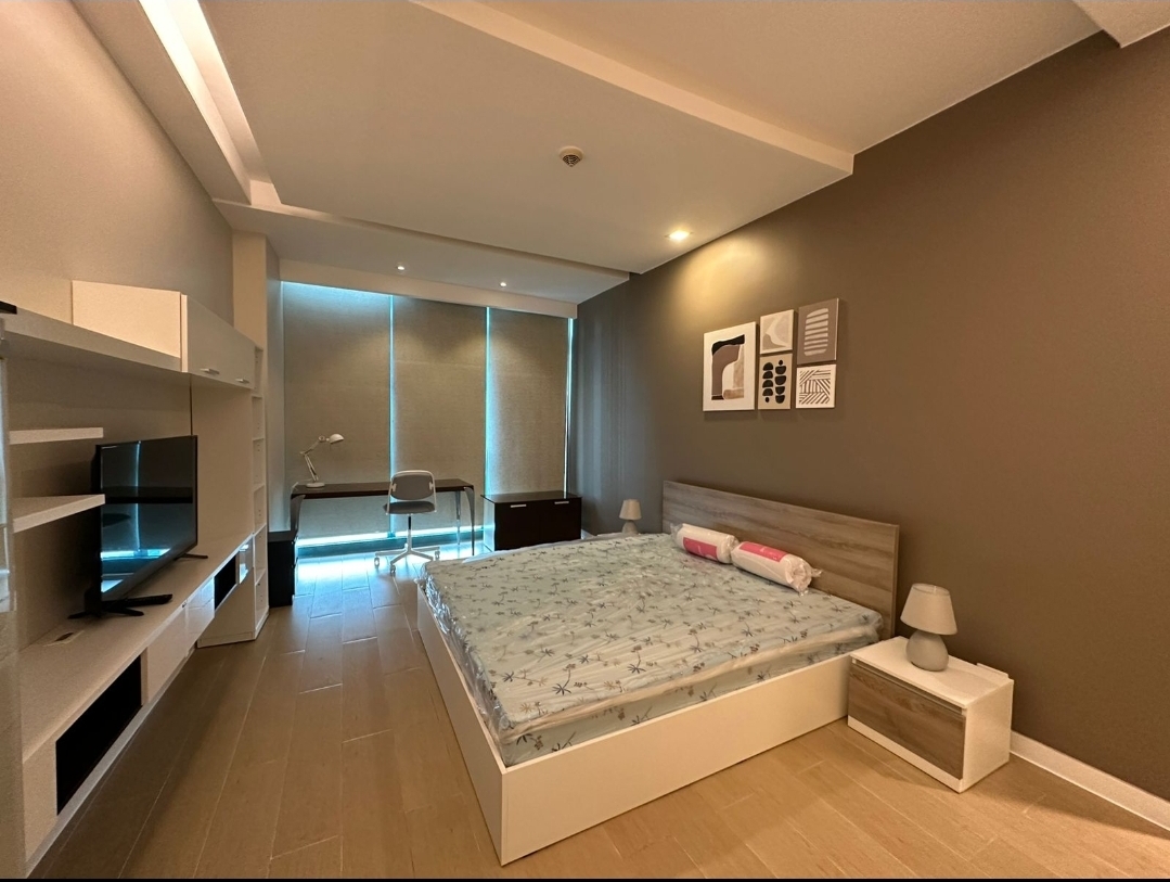 Master bedroom with study desk, TV wall, and blackout blinds