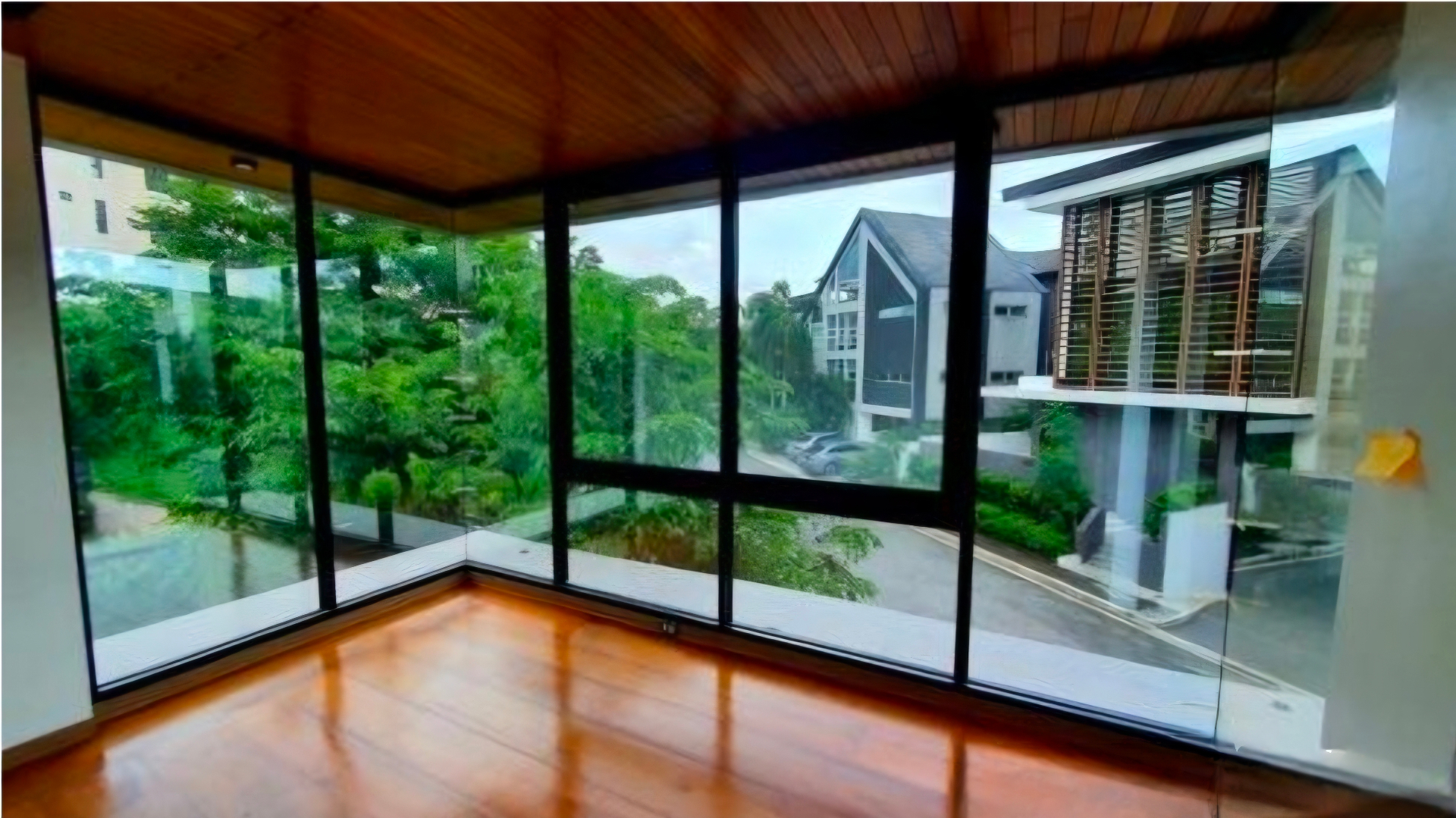 Corner room wrapped in glass with Narra flooring and garden views
