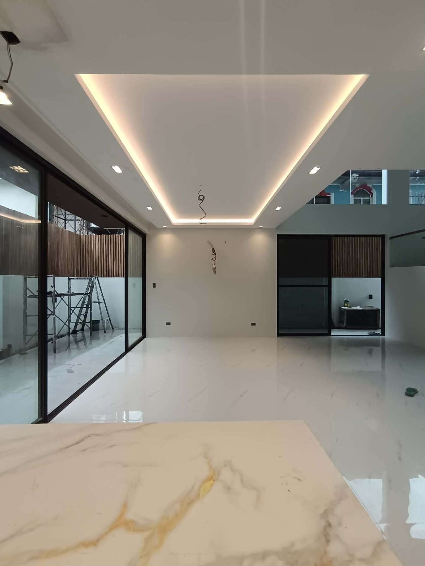 Open-plan living area with cove-lit ceiling and marble island