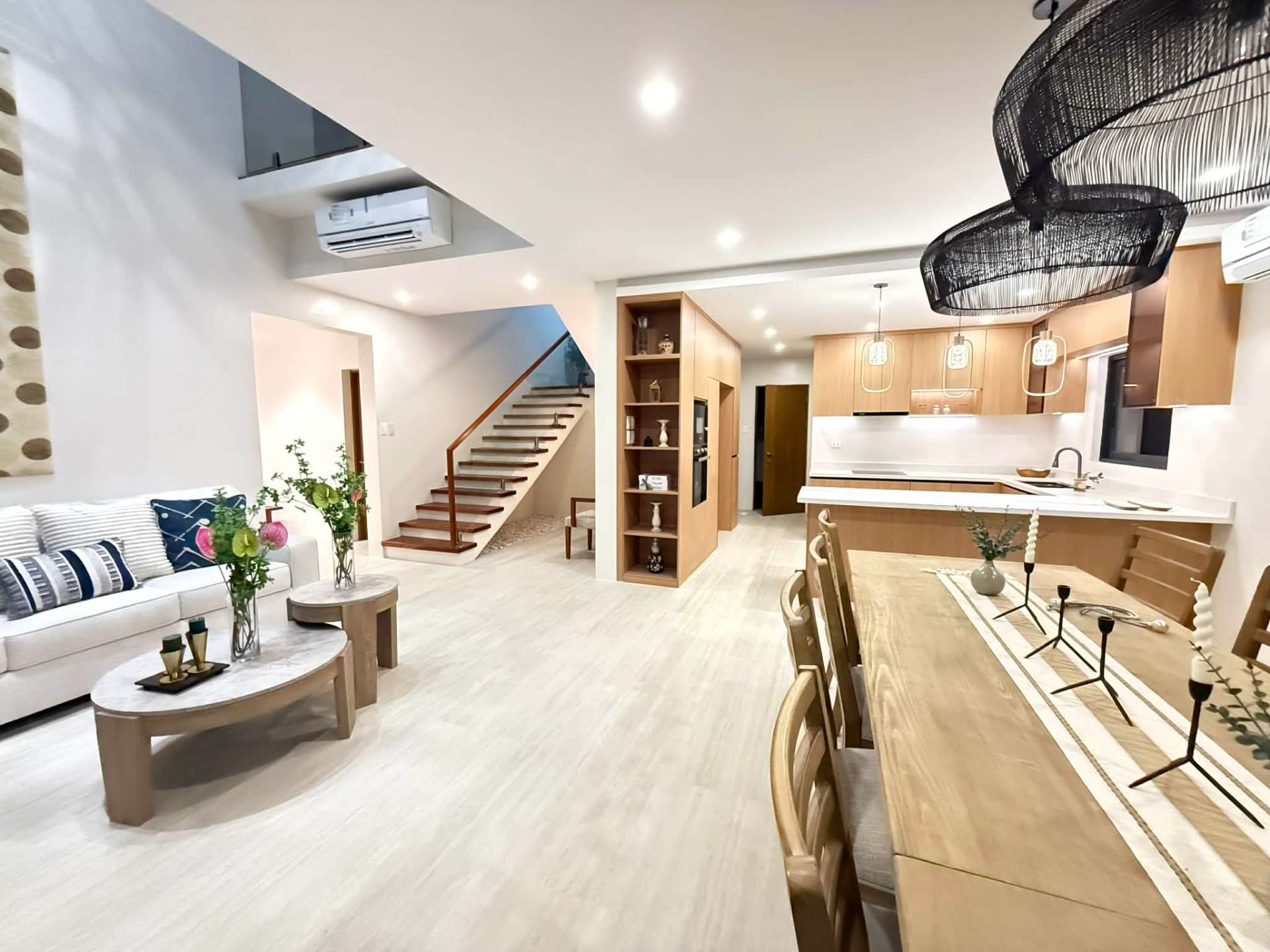 Living room, staircase, and open-plan kitchen viewed across the great room