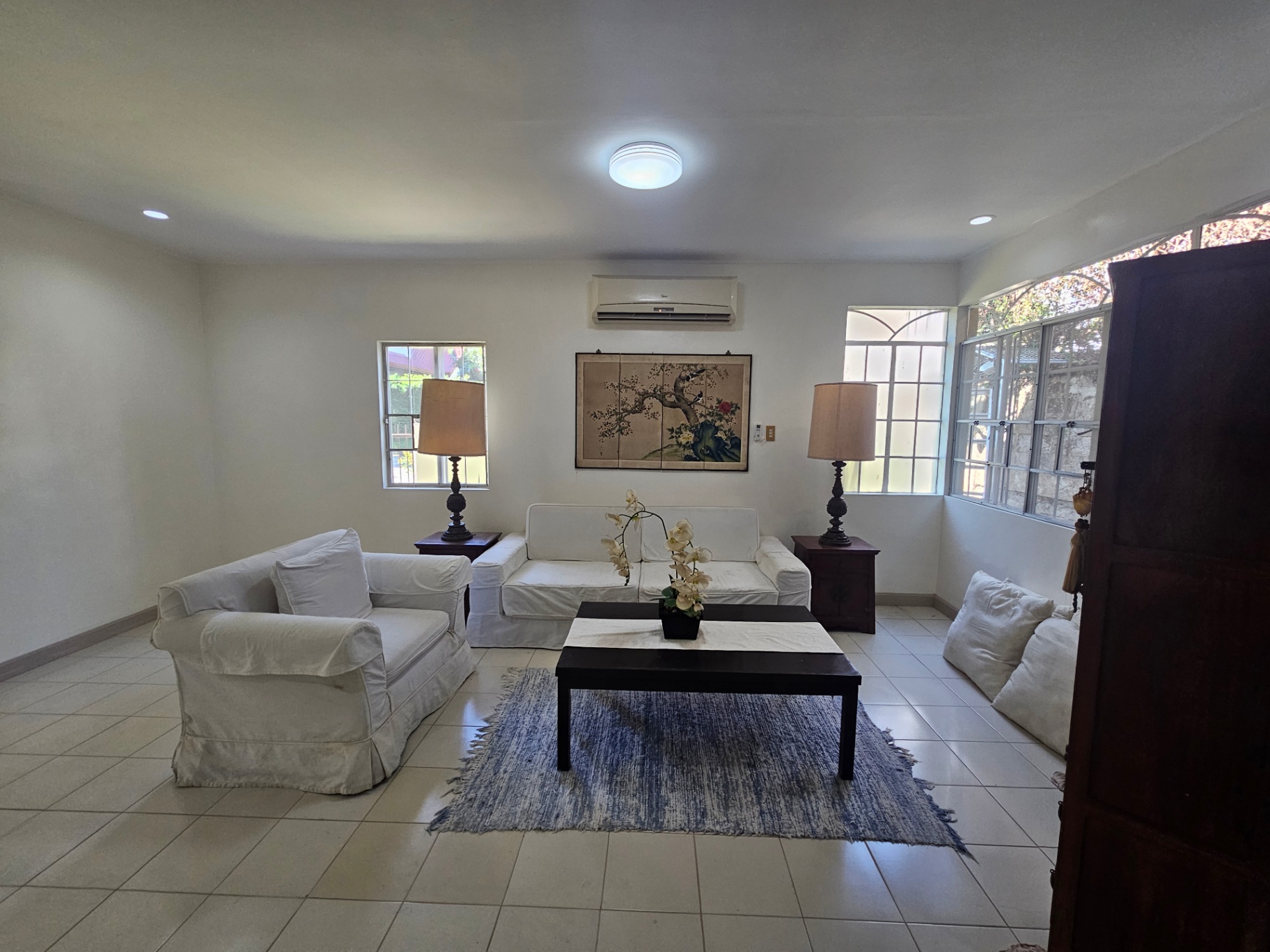 Living room with slipcovered sofas, twin table lamps, and Asian screen artwork