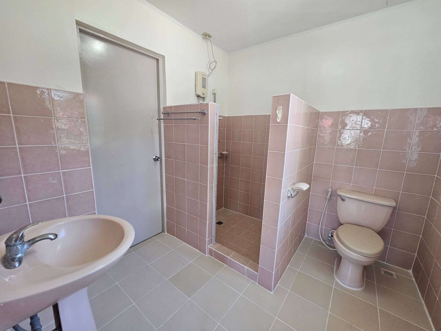 Bathroom with pink wall tiles, walk-in shower, and vanity