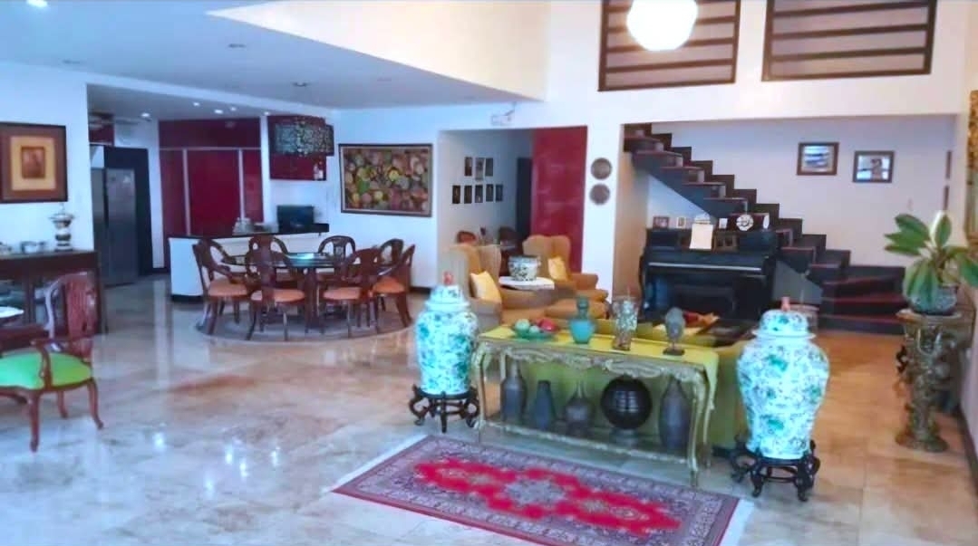 Grand living area with staircase, dining set, and marble floors
