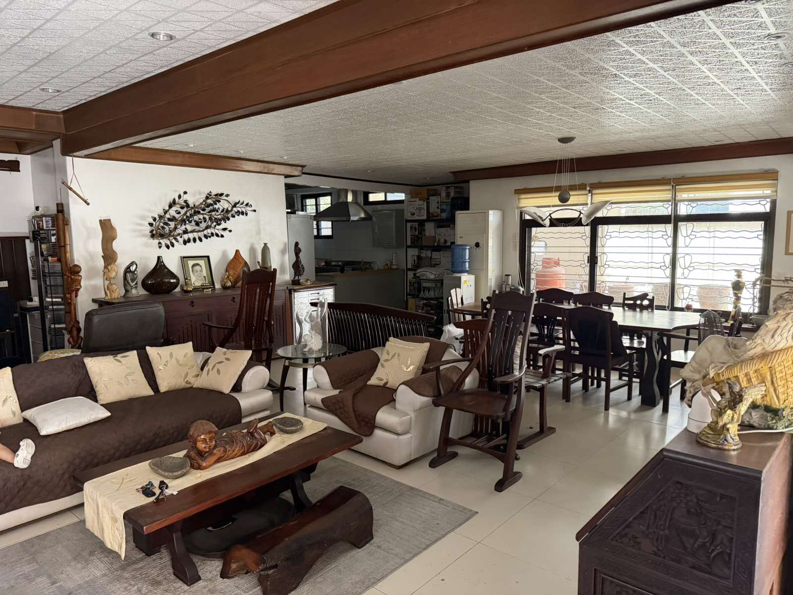 Open-plan living and dining area with warm wood beams
