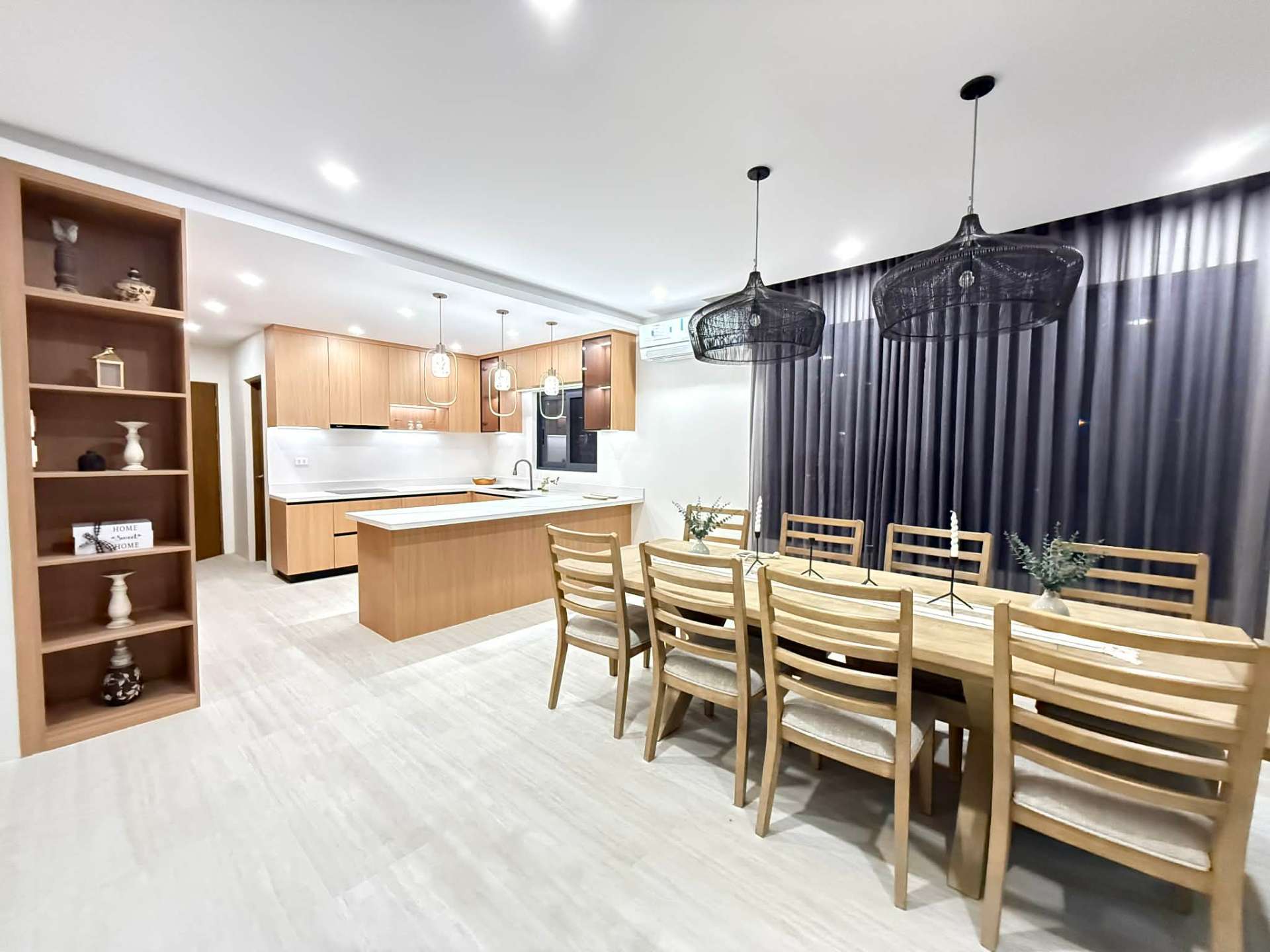 Open-plan kitchen with wood cabinetry and a long formal dining table