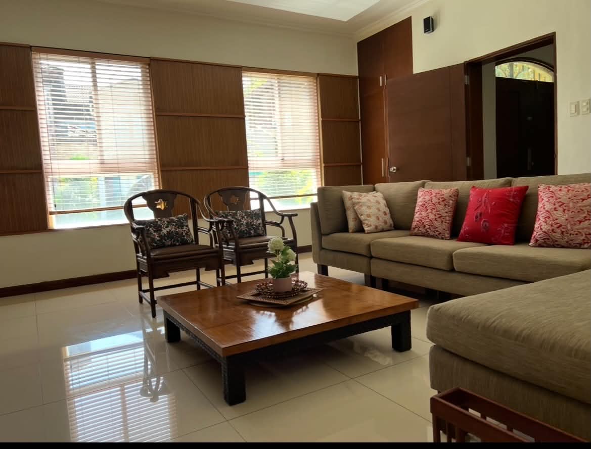 Spacious living room with sectional sofa and bamboo-blind windows