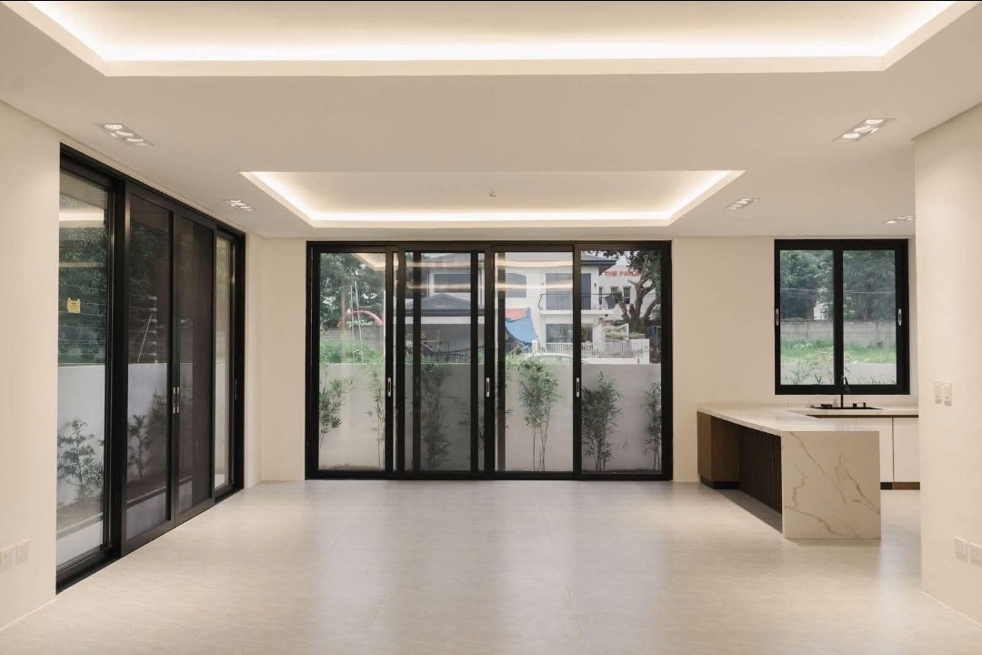 Great room with cove-lit ceiling, folding glass doors and marble counter
