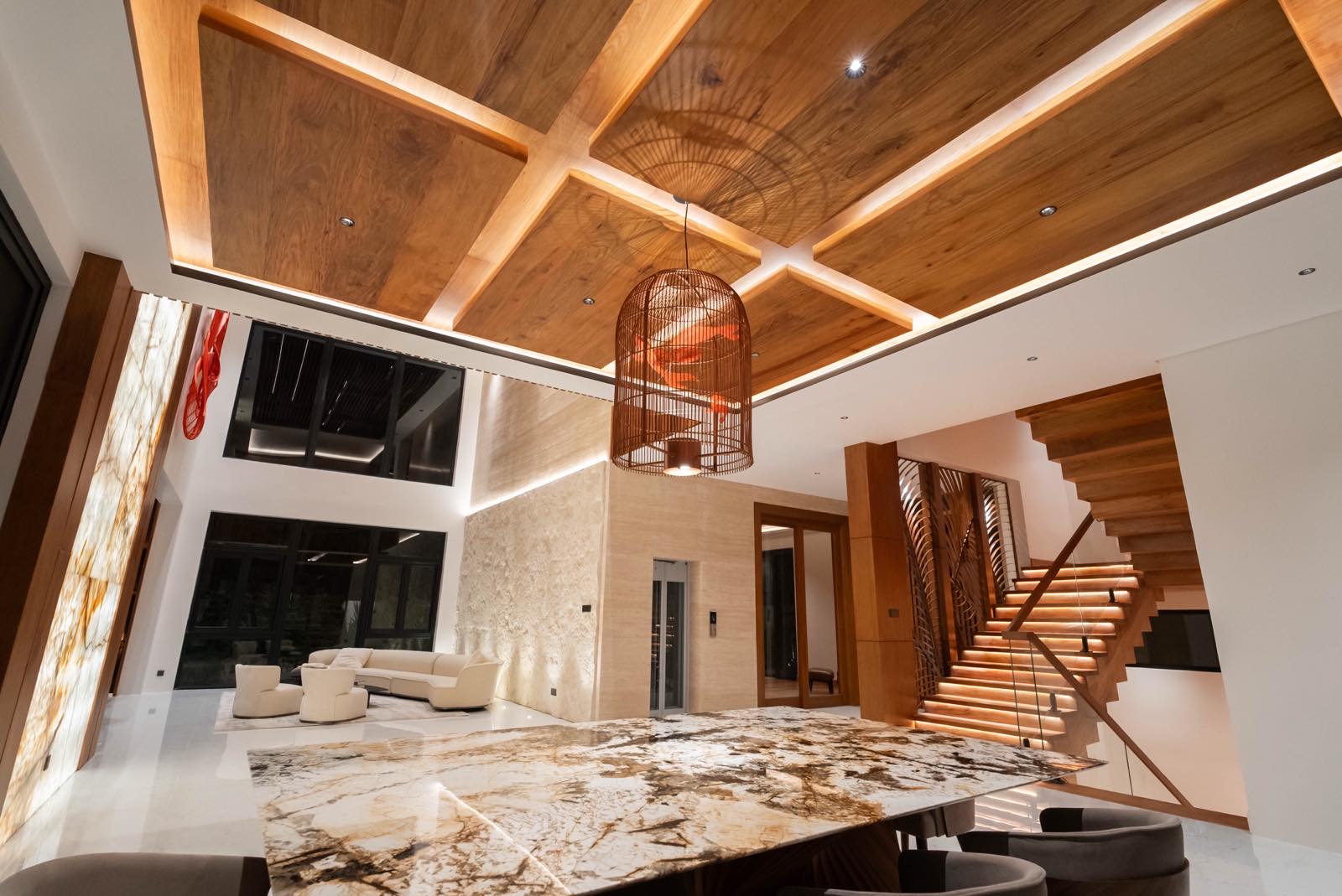 Great room with coffered narra ceiling, backlit onyx walls and marble island