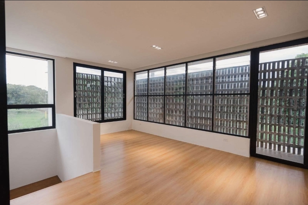 Upper room with timber flooring framed by the breeze-block screen wall