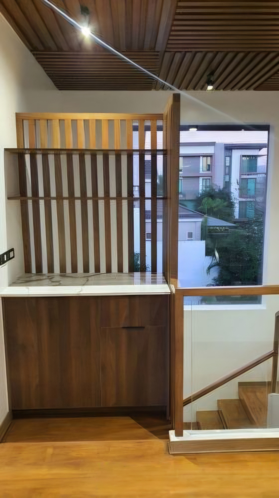 Wood-slat partition and marble console with village views