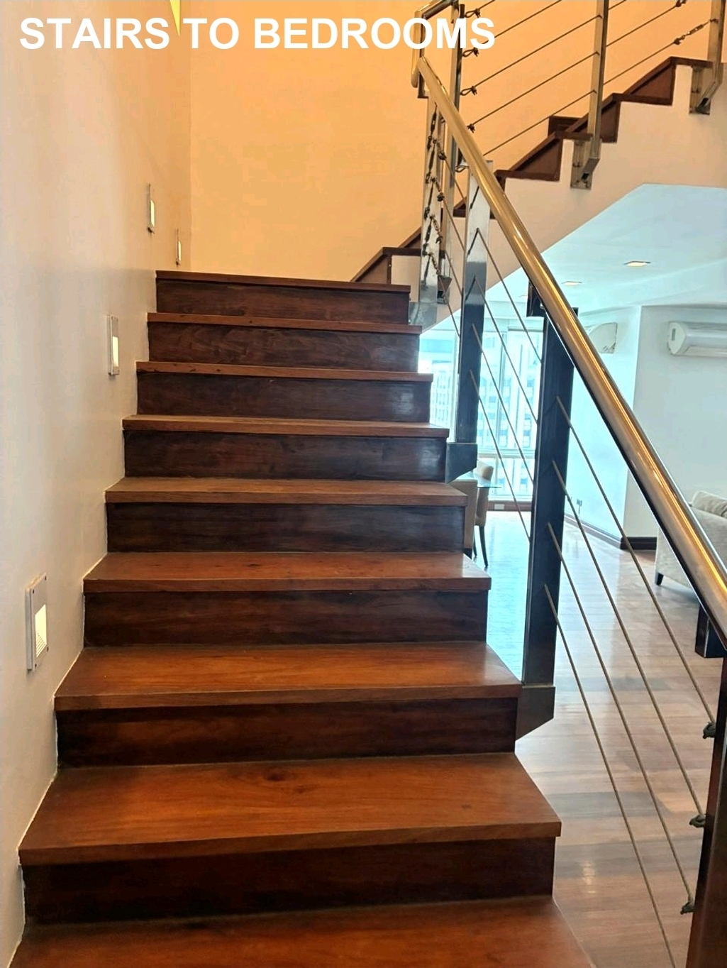 Solid wood staircase with cable railing leading to the bedrooms