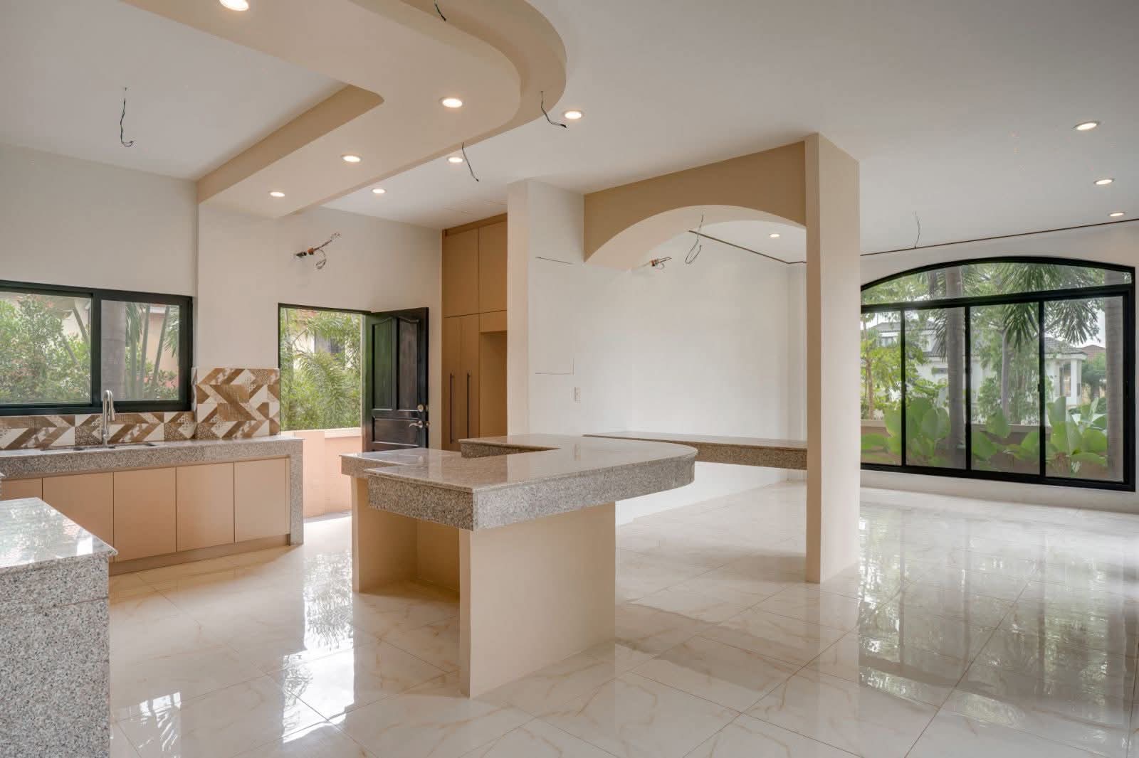 Open-plan kitchen and dining area framed by garden-view windows