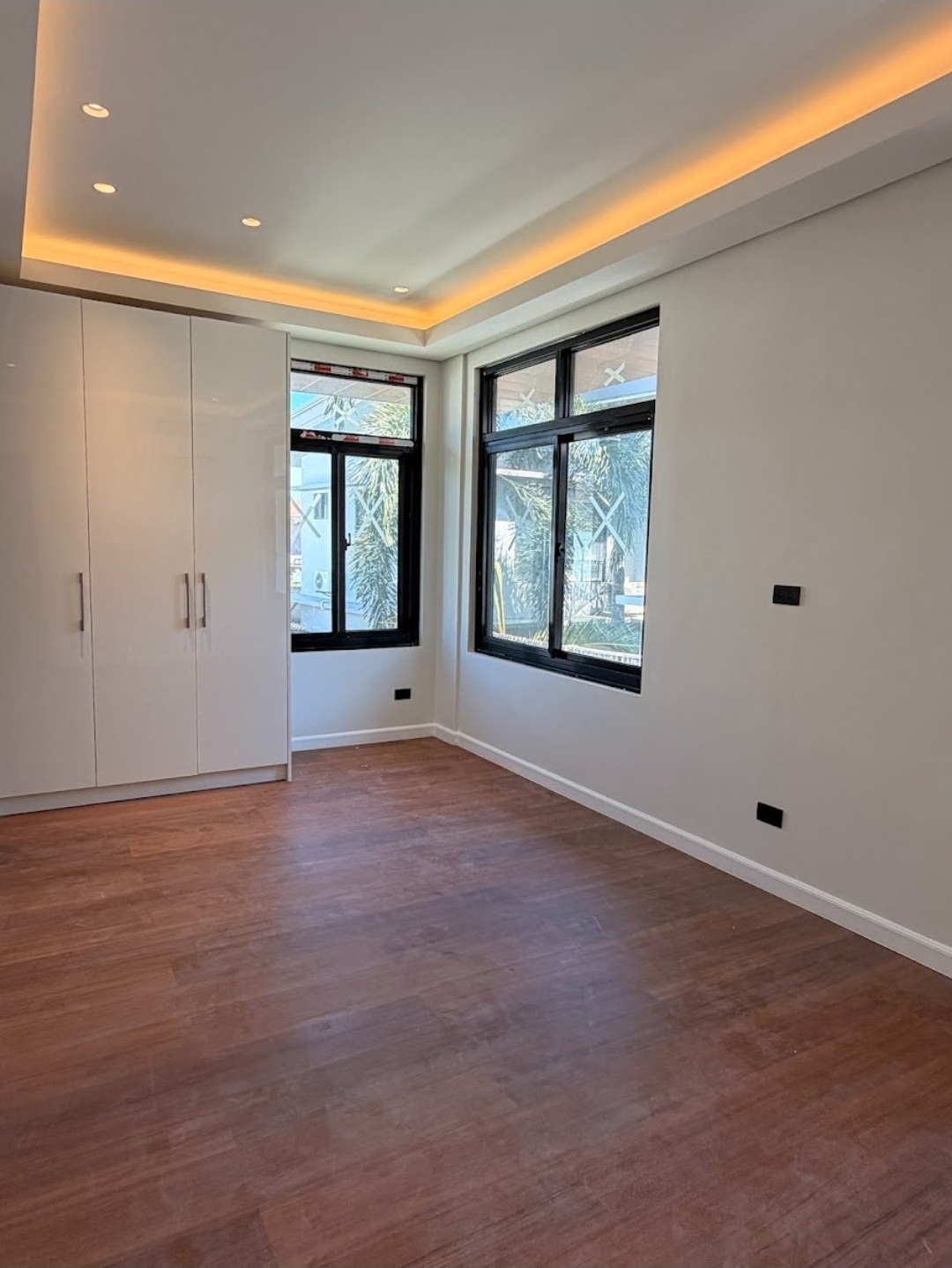 Master bedroom with corner windows and built-in wardrobe