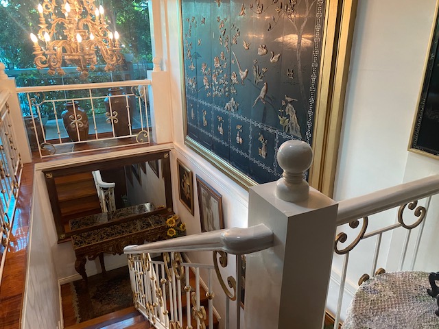 Sweeping staircase with chandelier and hardwood steps