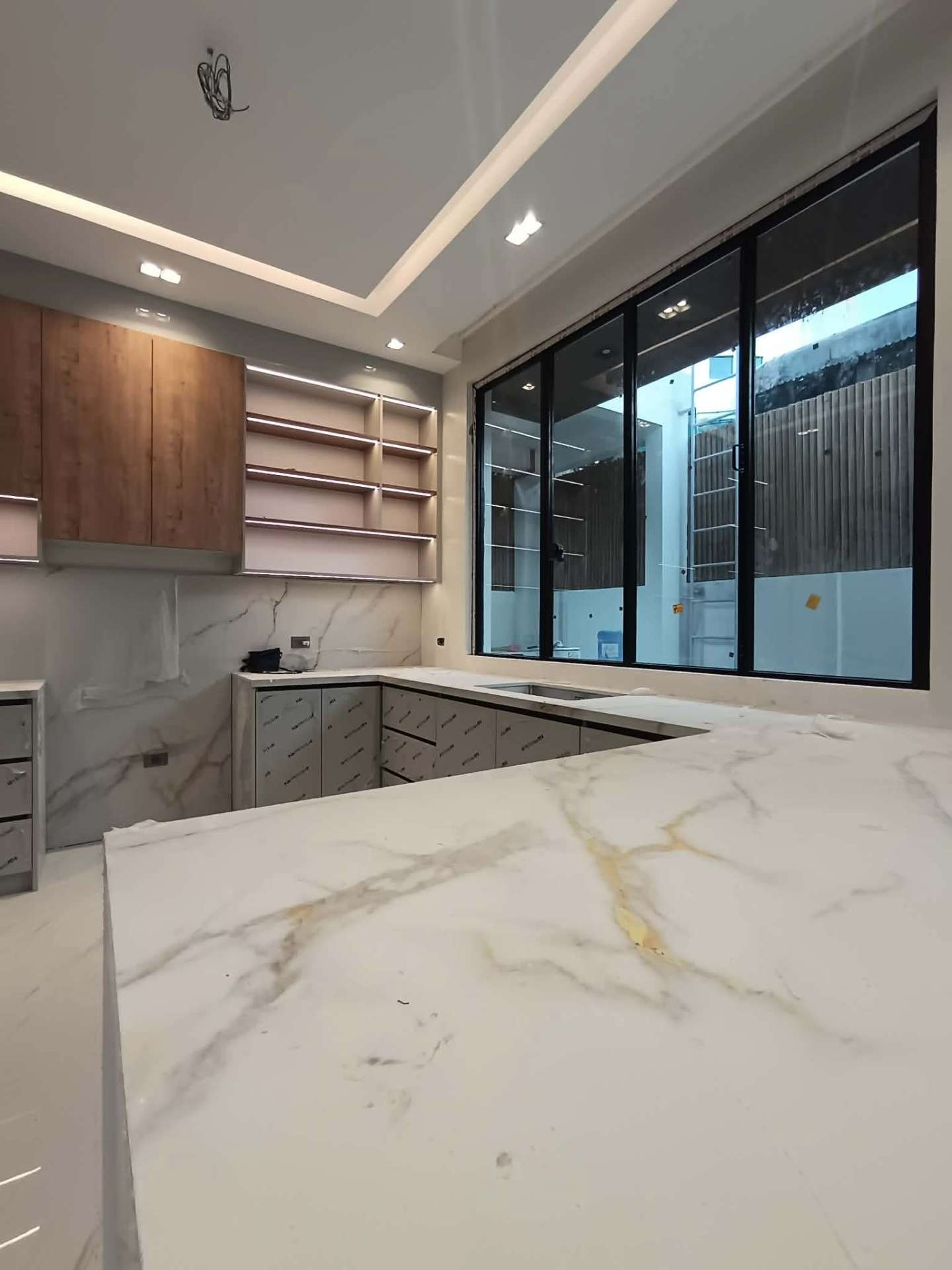 Kitchen with marble countertop, warm cabinetry, and picture window