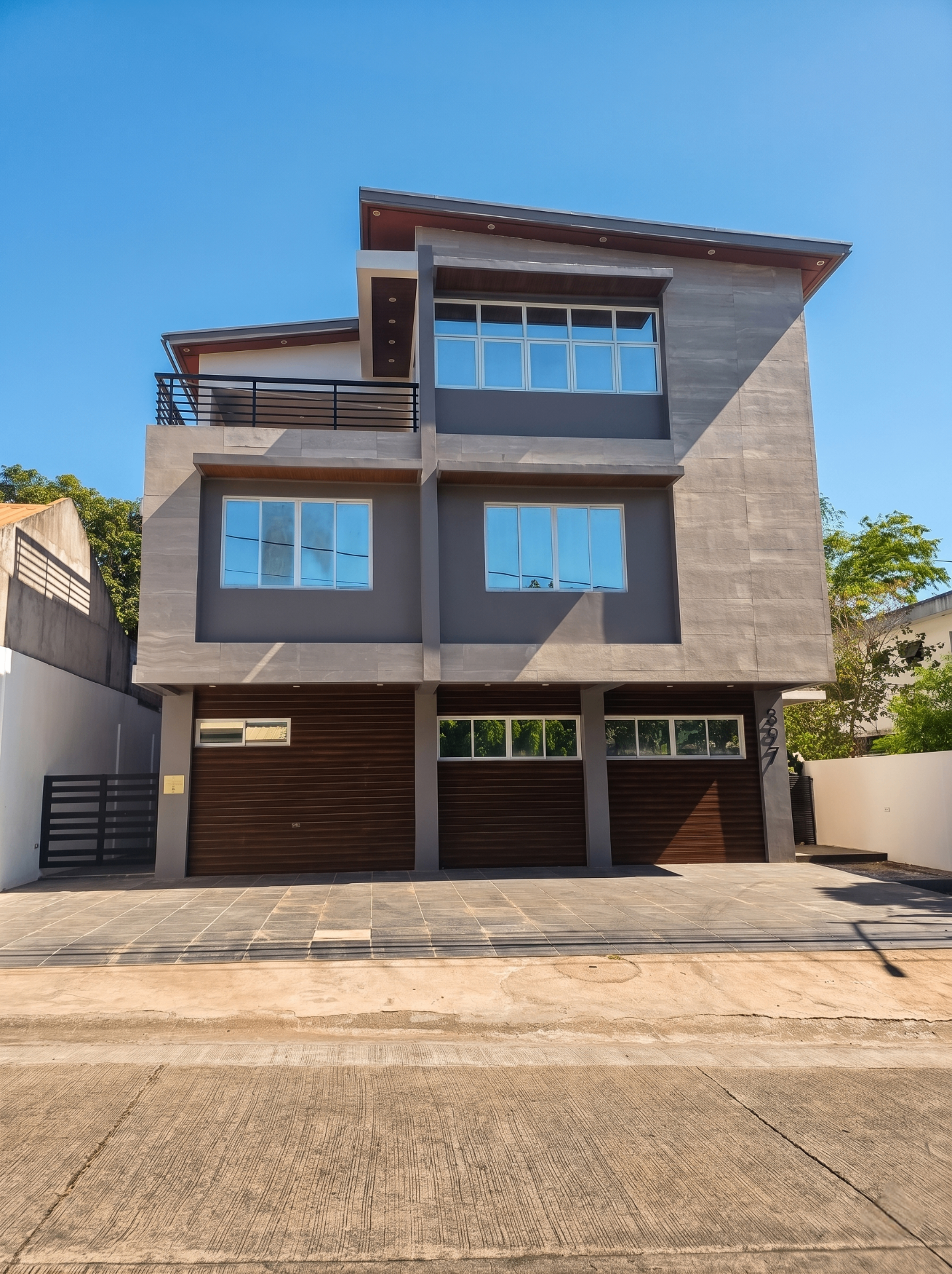 Brand new three-storey modern facade with wood-clad garage doors in Ayala Alabang