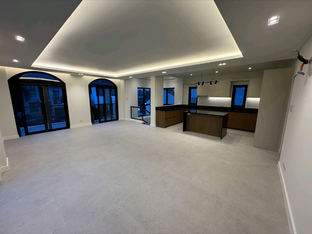 Open-plan upper ground living and dining space with cove lighting and view to modern kitchen