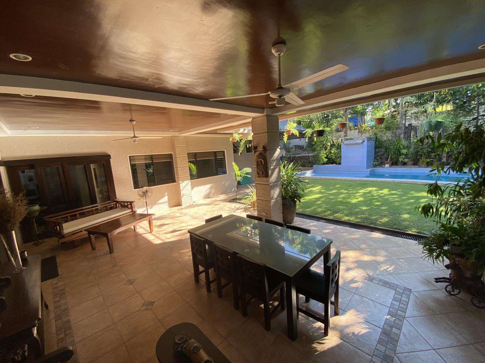 Outdoor lanai dining area opening to the garden and pool