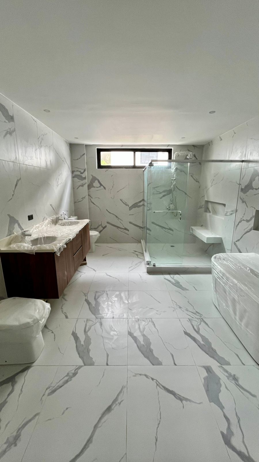 Spa-like master bathroom in marble with dual vanities, glass rain shower, and free-standing tub