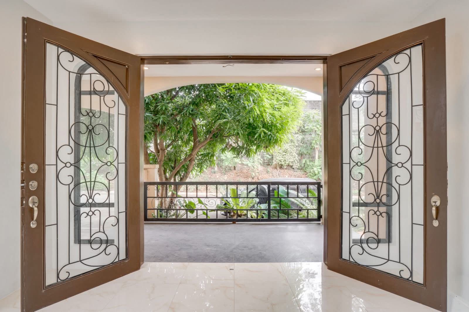 Decorative wrought-iron double doors opening to the balcony and garden