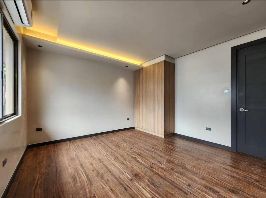 Bedroom with wood-slat feature wall and dark-framed door