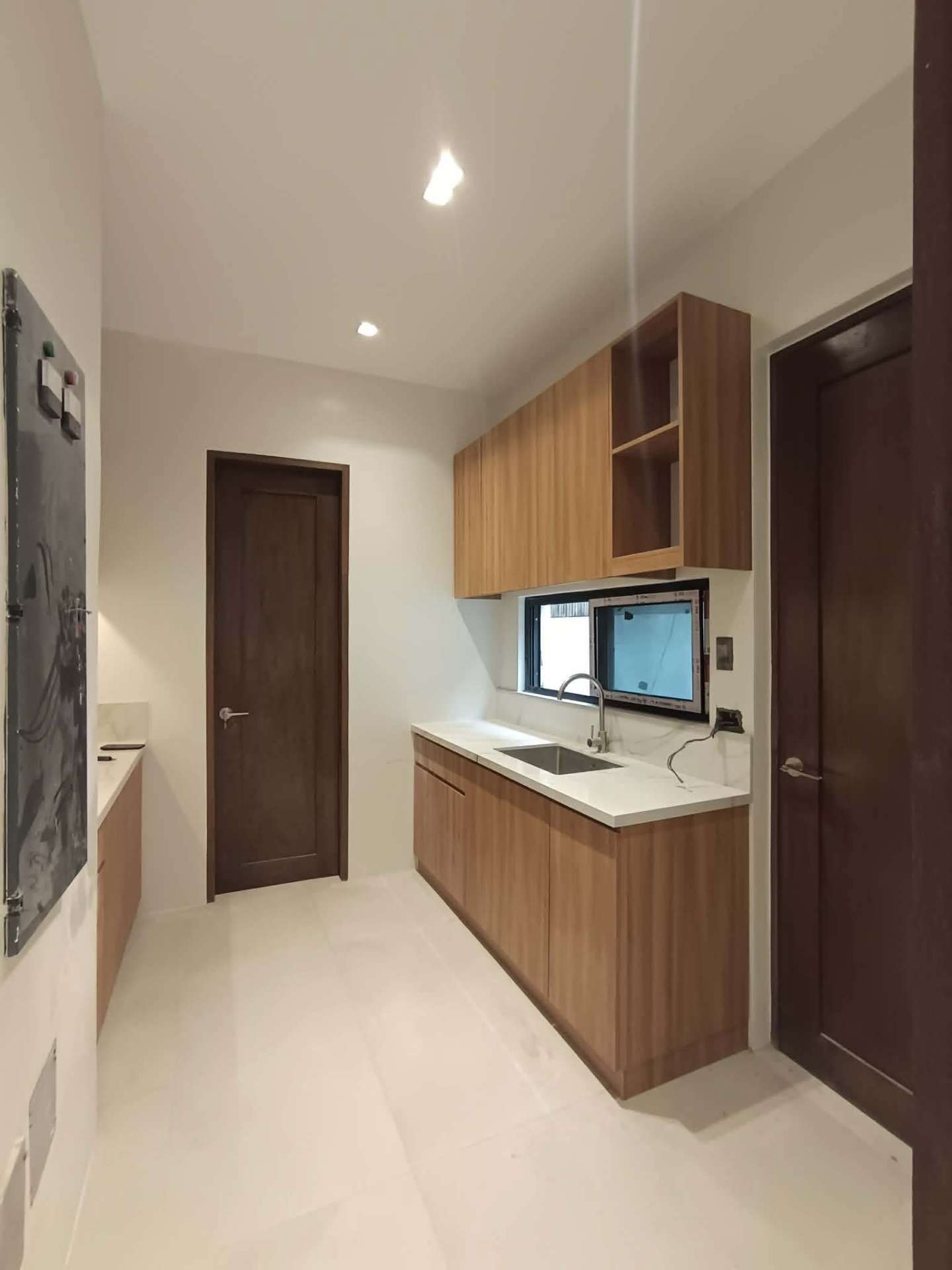 Service kitchen with wood cabinetry and sink