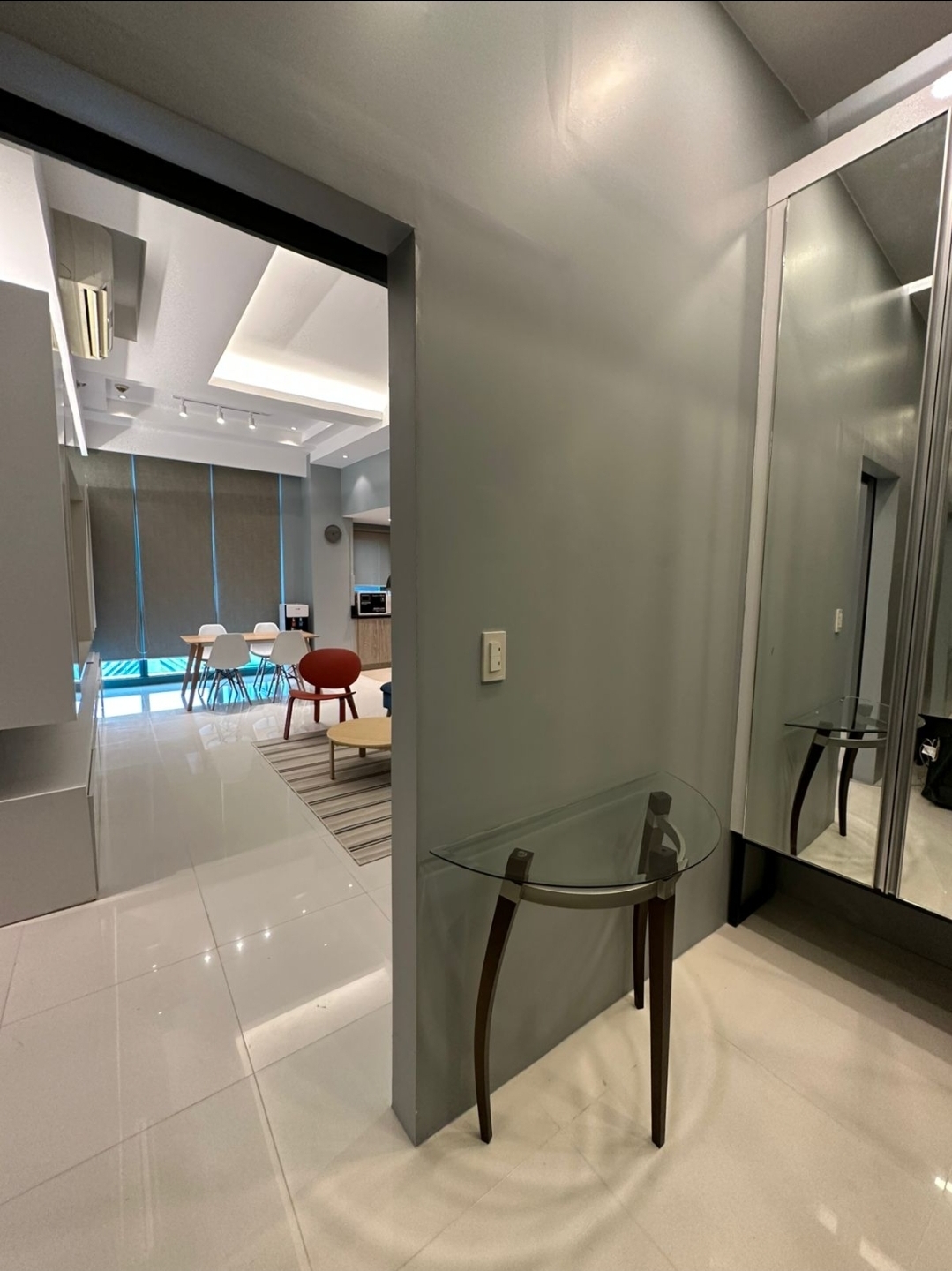 Foyer with console table, mirror wall, and view into the living area