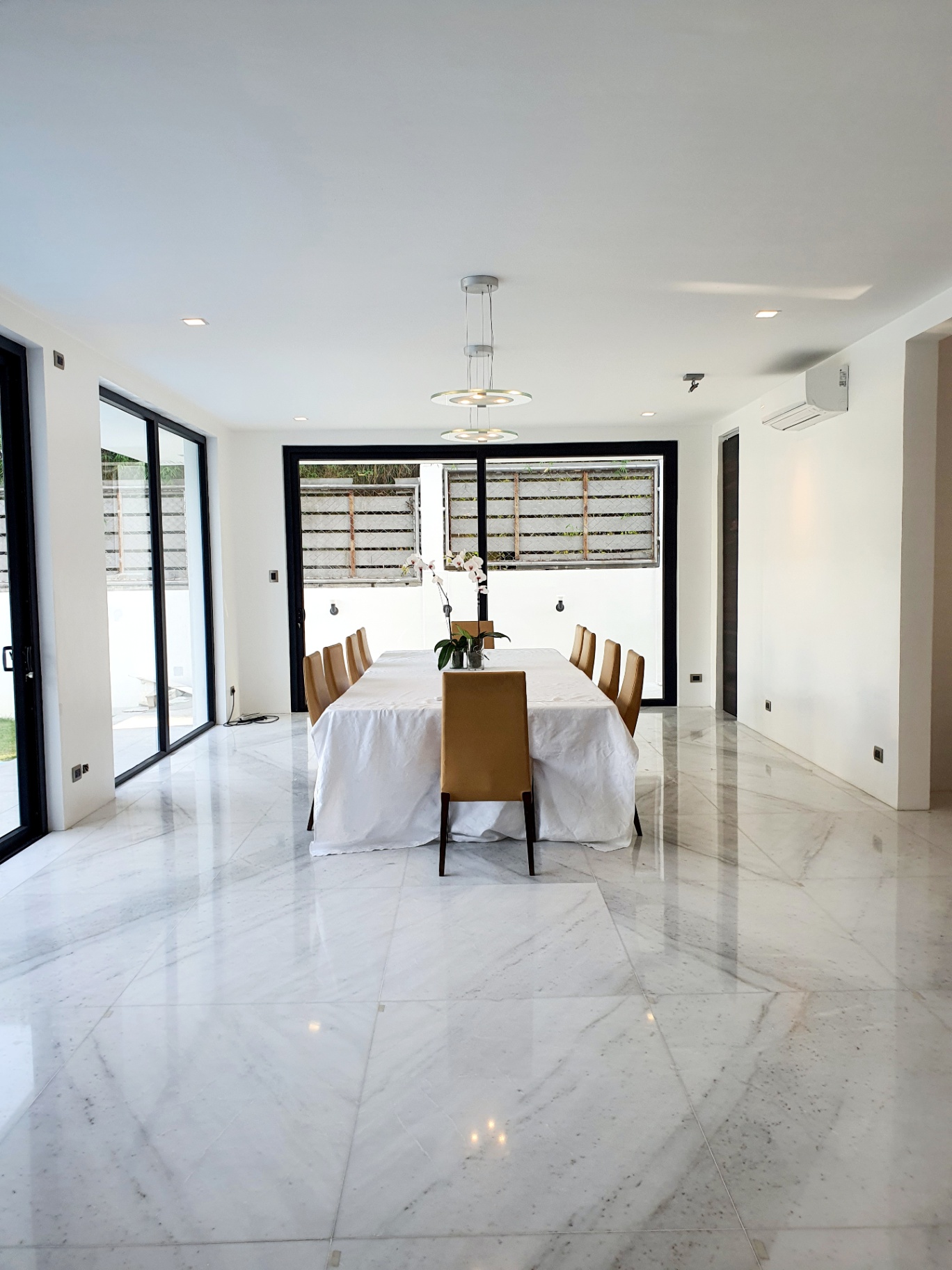 Formal dining room with marble floors and sliding glass walls