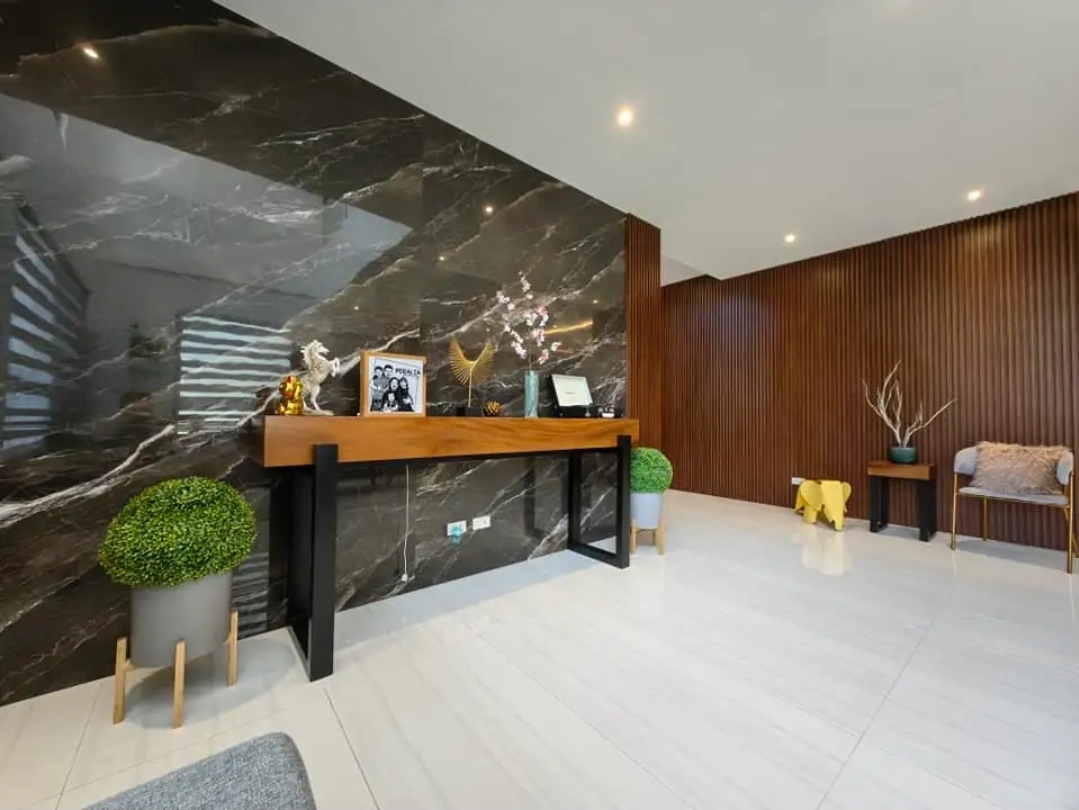 Grand foyer with marble accent wall and wood-slat panelling
