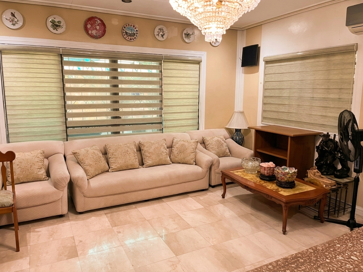 Cozy lounge with chandelier, beige seating, and large windows