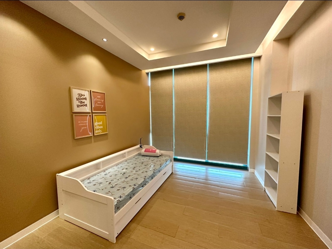 Third bedroom in warm tones with daybed and open shelving