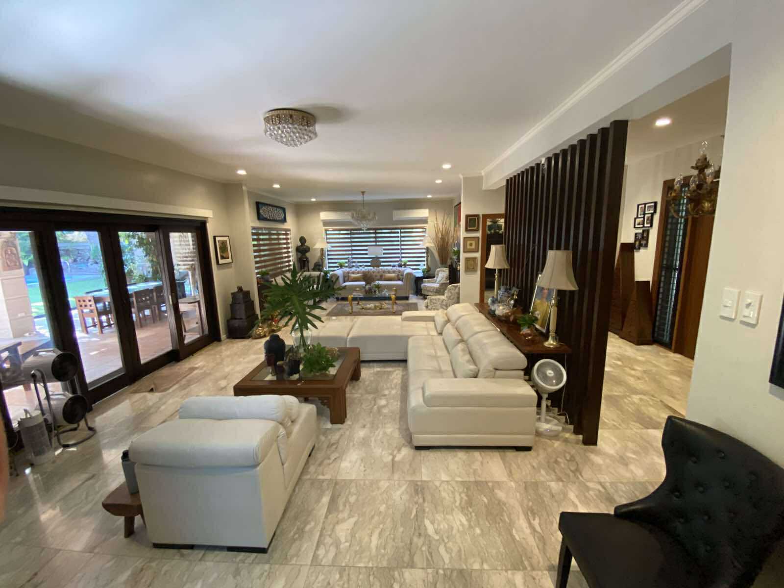 Formal living area in marble flooring with wood slat partition and garden doors