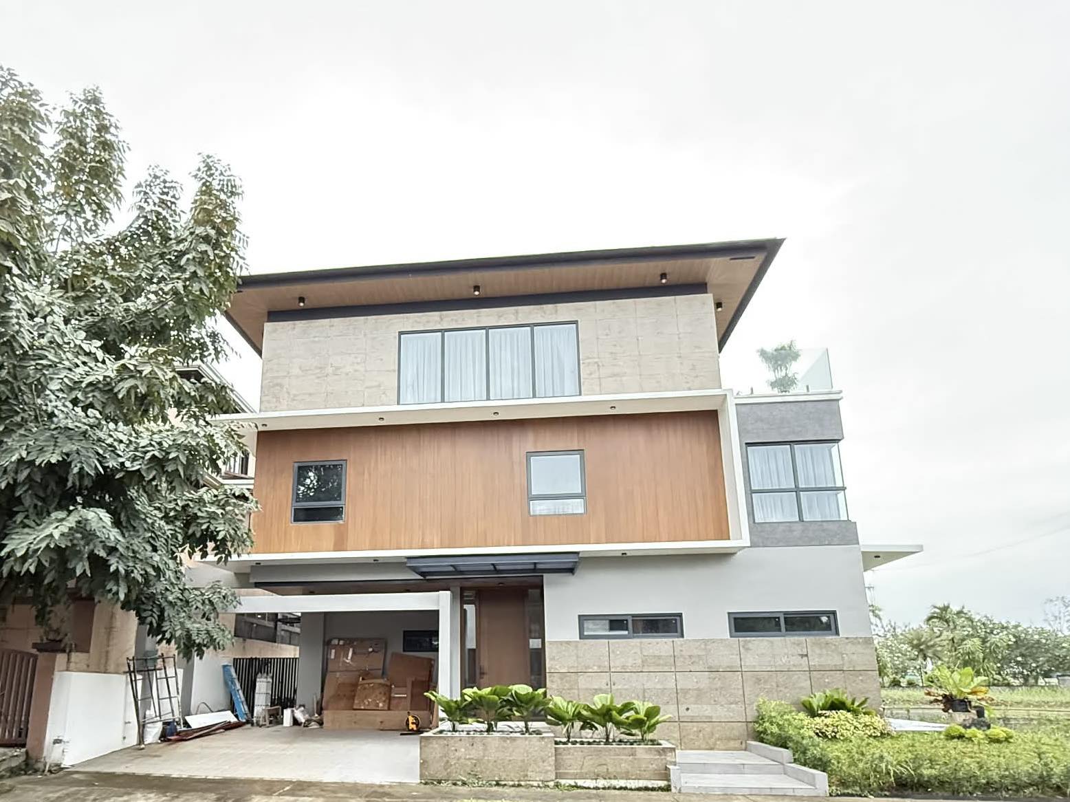 Front elevation showing the wood-clad facade and covered car garage