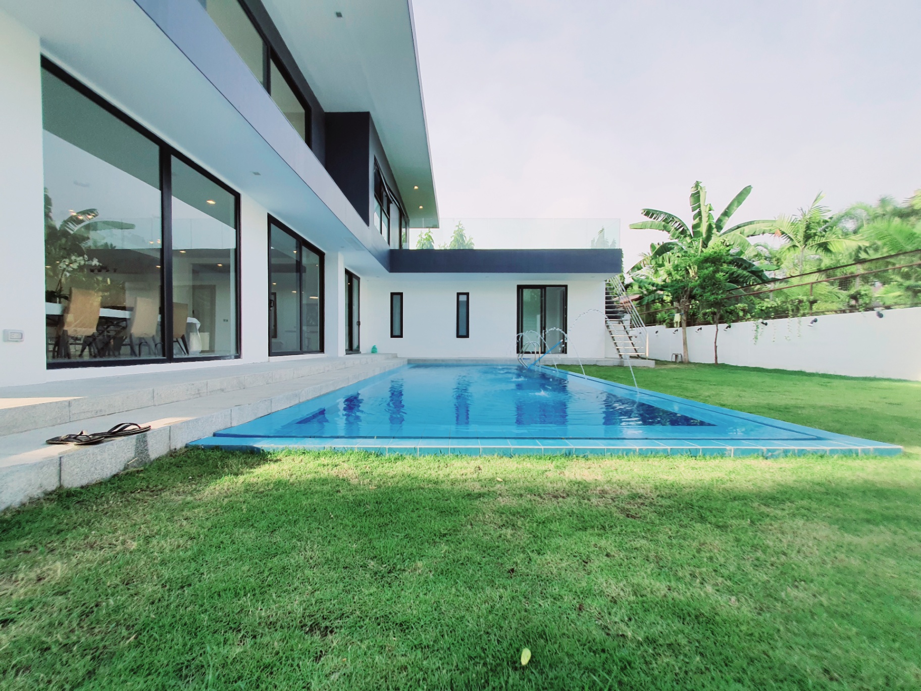 Swimming pool with fountains beside the home