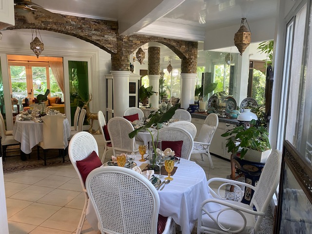 Sun-lit lanai dining beneath stone archways