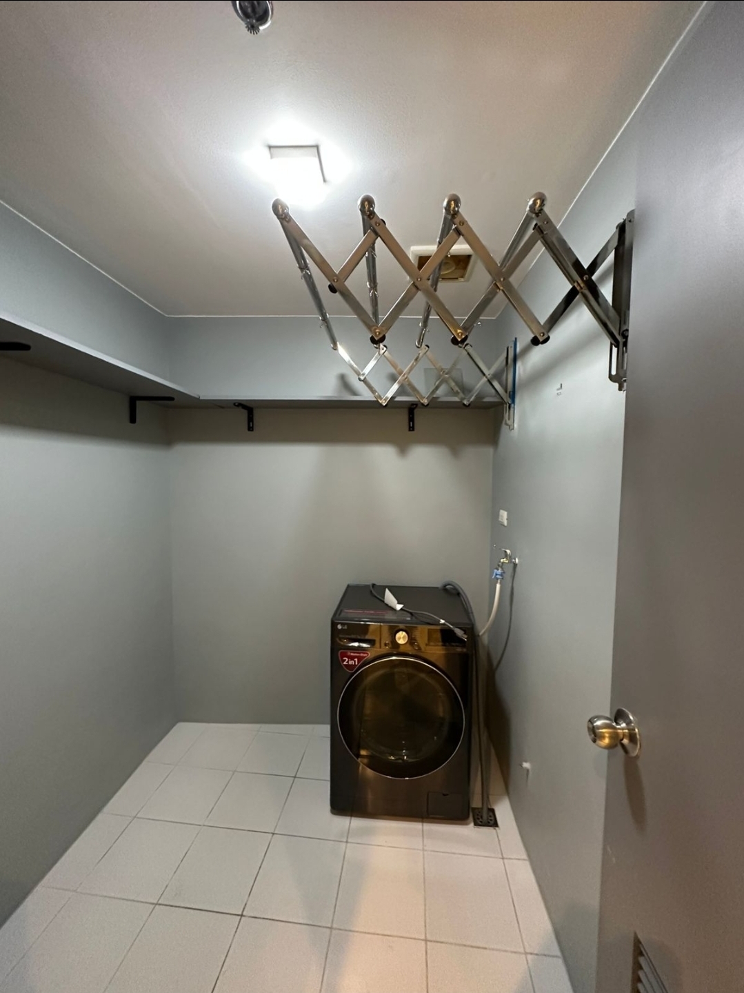 Utility room with front-load washer-dryer and ceiling laundry rack