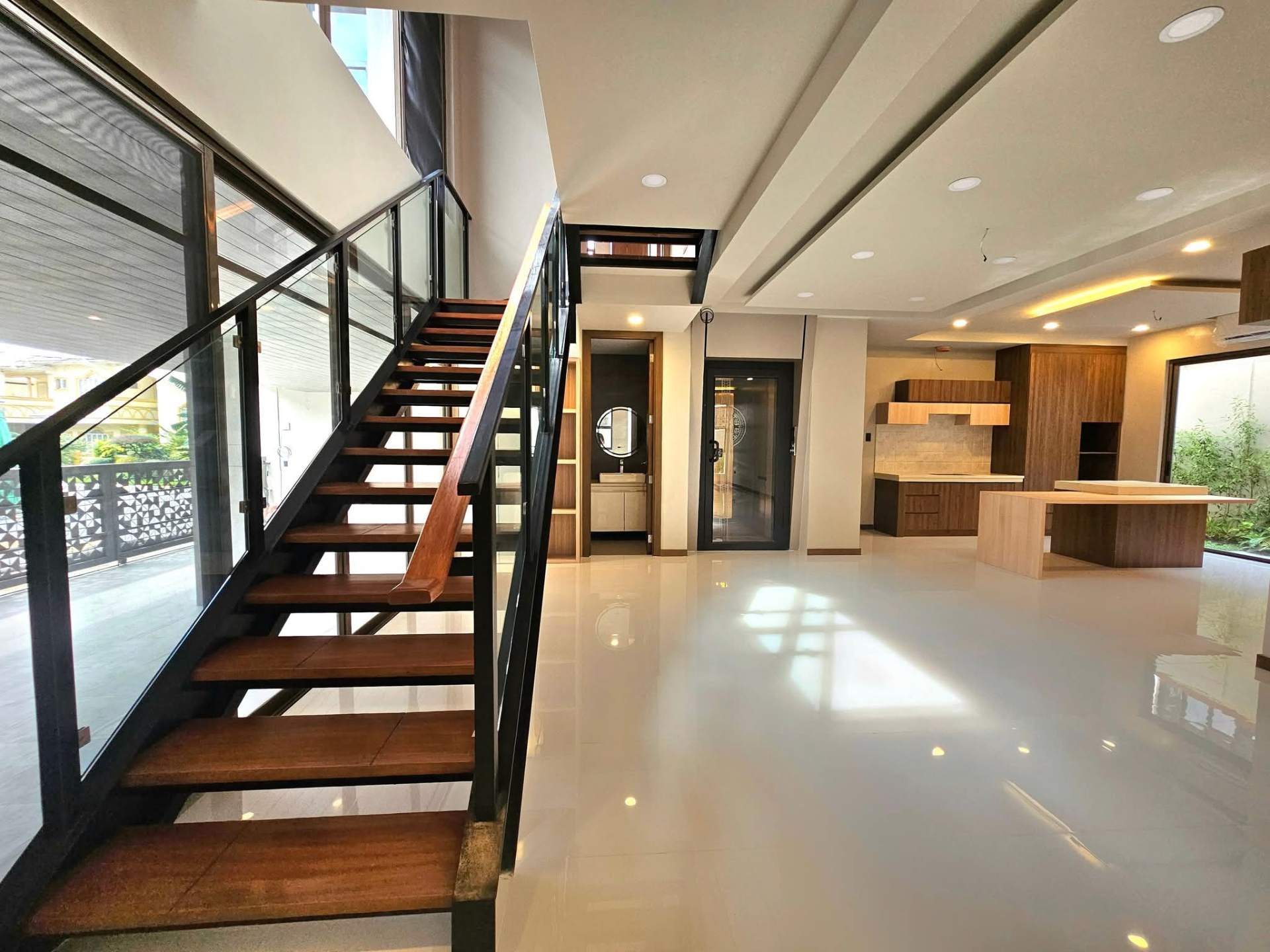 Floating wood-and-glass staircase beside the open living space