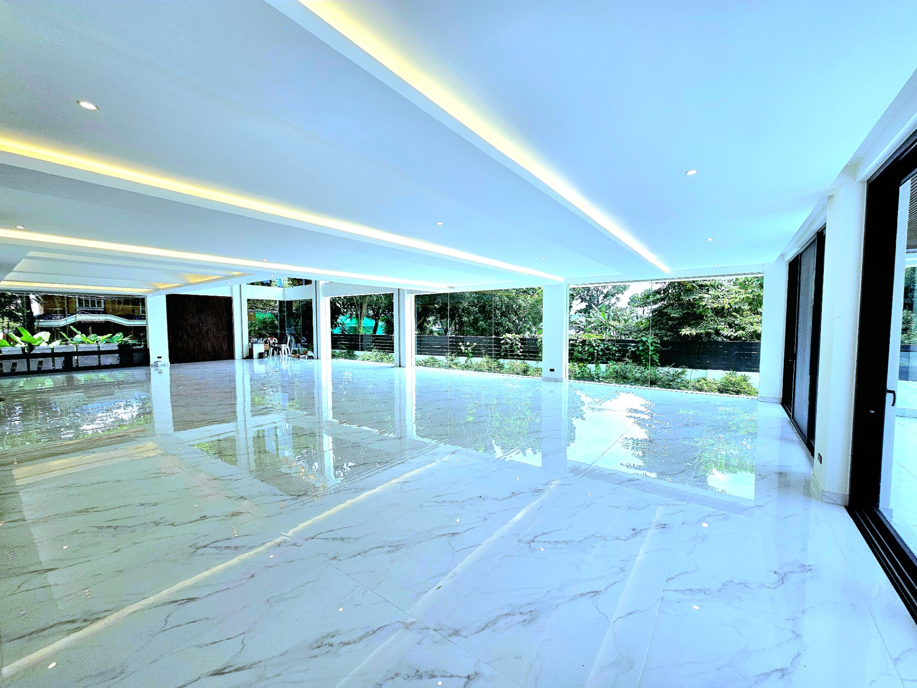 Expansive marble-floored living space wrapped in floor-to-ceiling glass