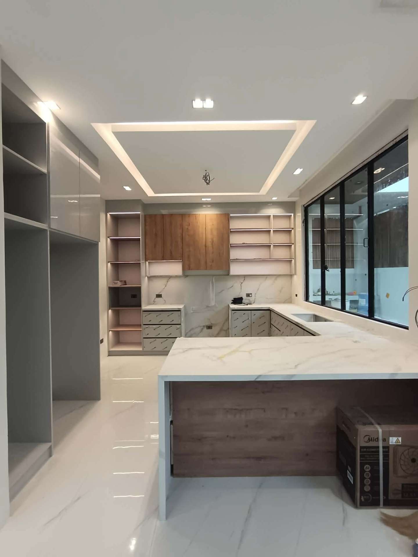 Wide kitchen view with feature ceiling and floor-to-ceiling glass