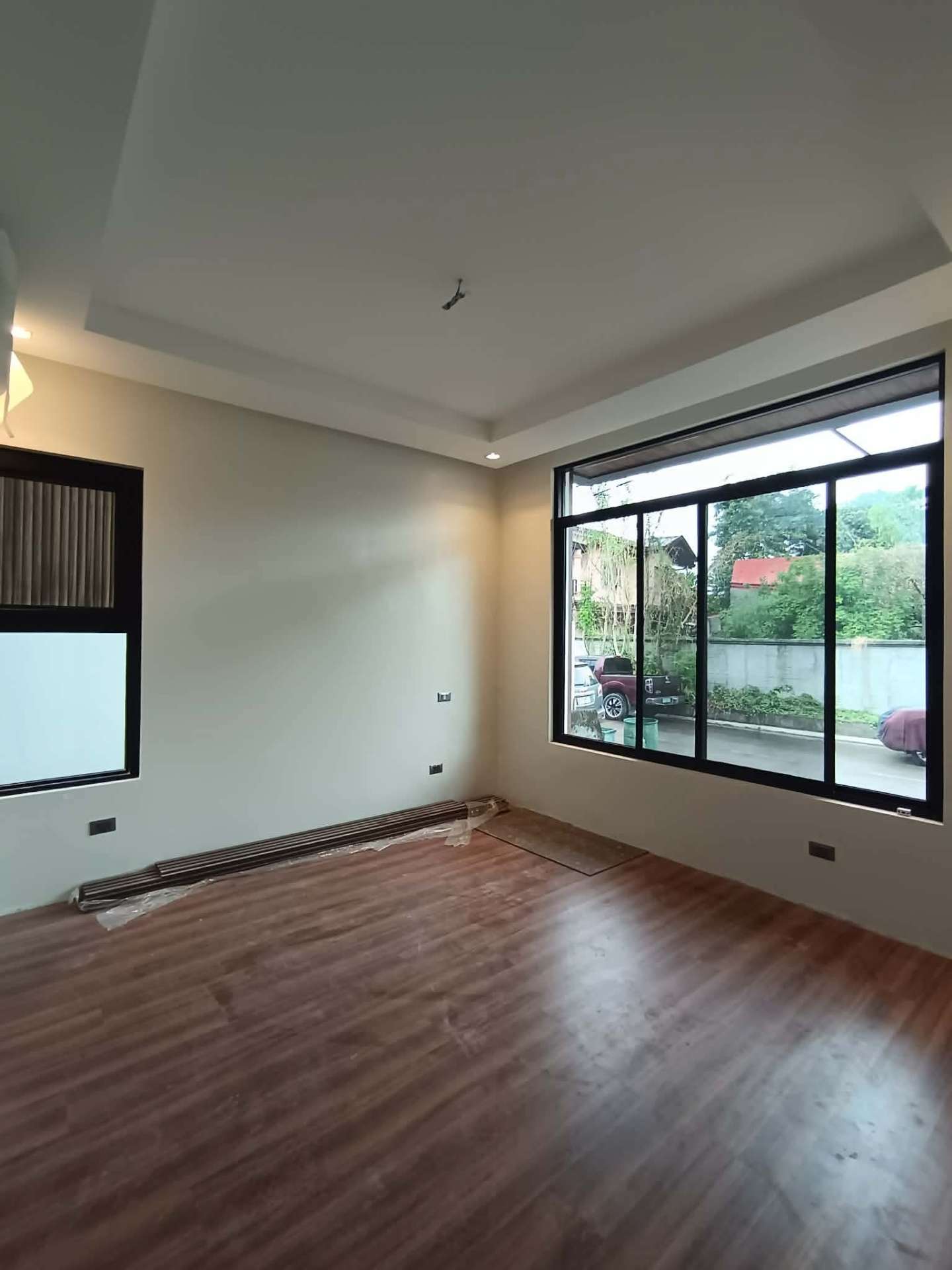 Spacious bedroom with wood flooring and a large picture window