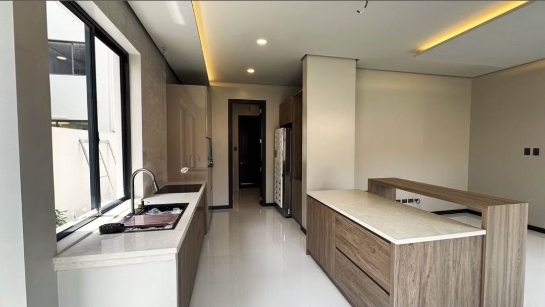 Daily kitchen with stone counters, wood cabinetry and pantry access