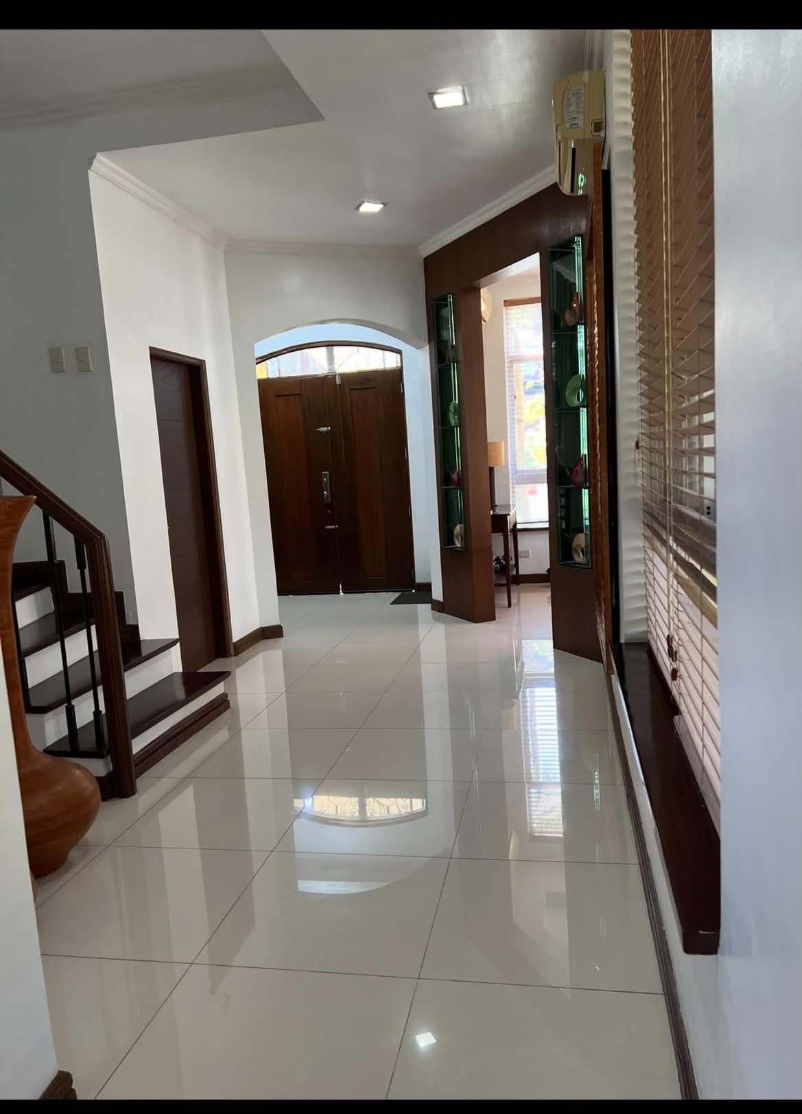 Grand foyer with arched wooden double doors and glass display niches