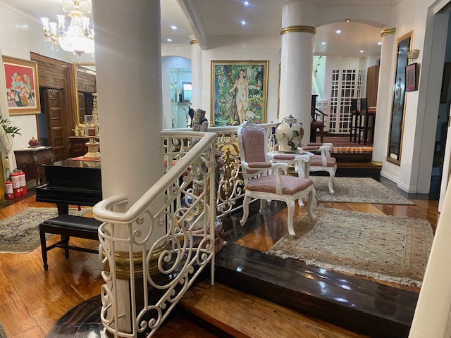 Staircase landing with wrought-iron balustrade and art