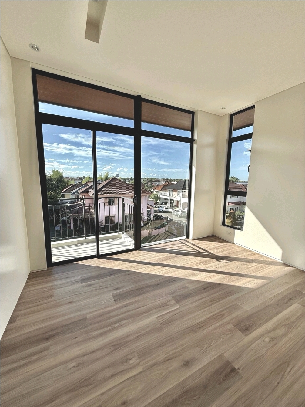 Corner bedroom with floor-to-ceiling glass and balcony